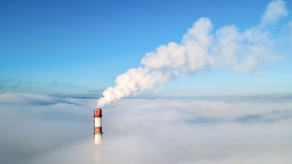 waste incineration with smoke coming out of smokestack into blue sky